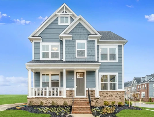 Bright exterior of a light blue Lennar Home for sale at Greenleigh under a bright blue sky